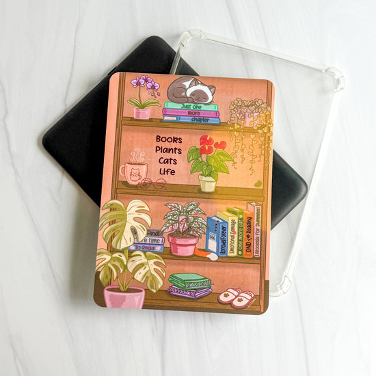 1. Books Plants Cats Life foiled Kindle insert with cozy bookshelf illustration, Kittlins
2. Kittlins cozy shelfie Kindle insert shown under a clear case (device and case not included)
3. Close-up of deep pink foiled Books Plants Cats Life text on cardstock Kindle insert
